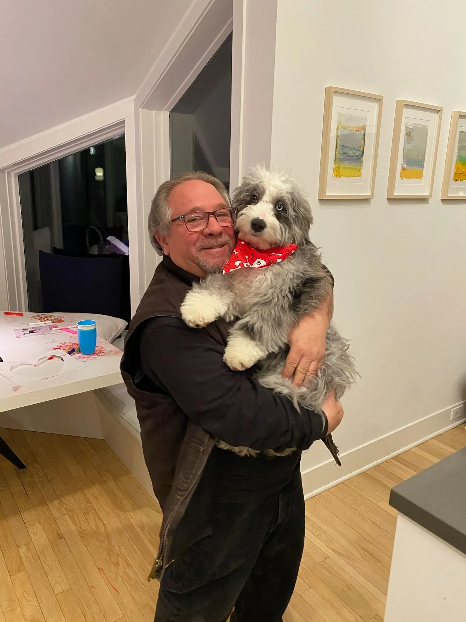 Robert holding a small dog indoors